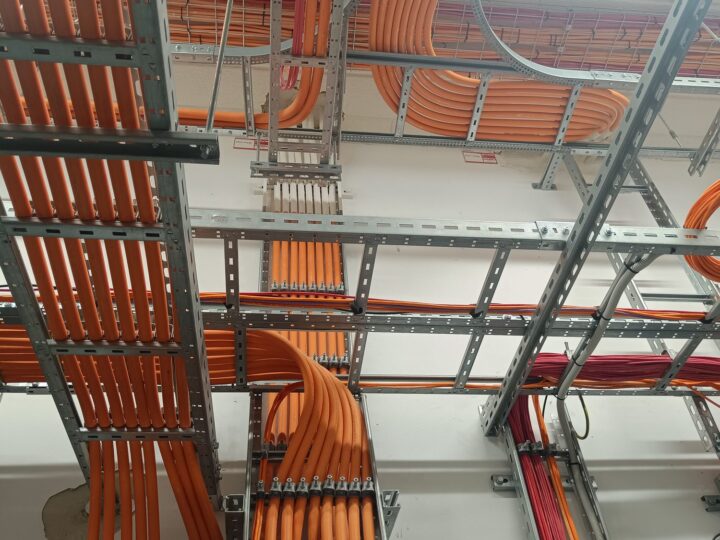 Trasy kablowe na korytkach pod stropem — instalacja elektryczna w budynku